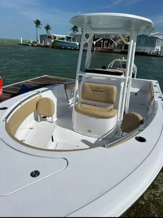 Slide: The Image of 2021 Sportsman Heritage 231 Center Console boat docked by the water. - 2