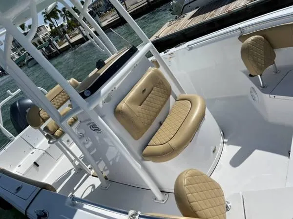 Slide: The Image of 2021 Sportsman Heritage 231 Center Console boat with tan quilted seating, docked by the water. - 5