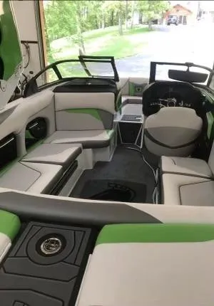 Slide: The Image of 2018 Centurion Ri217 boat interior with green and white seating, steering wheel, and dashboard. - 3