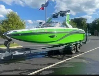 Slide: The Image of 2018 Centurion Ri217 boat in vibrant green on a trailer, parked outdoors. - 5