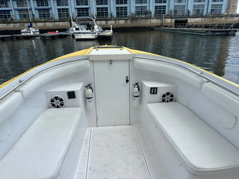 Slide: The Image of 1988 Wellcraft SCARAB SPORT boat interior with white seating and speakers, docked by the water. - 22