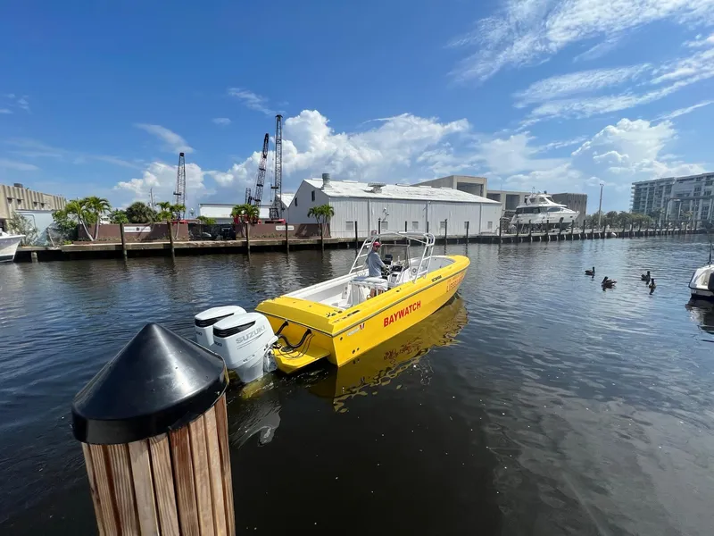 Slide: The Image of Yellow 1988 Wellcraft SCARAB SPORT boat docked in a marina under a blue sky. - 4