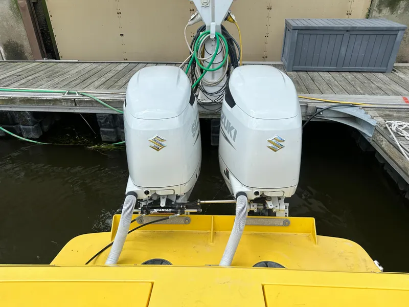 Slide: The Image of Twin Suzuki outboard motors on a 1988 Wellcraft SCARAB SPORT boat at dock. - 9