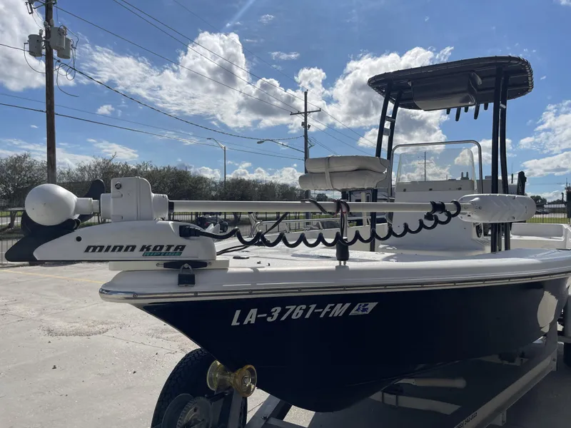 Slide: The Image of 2005 Sea Pro SV2100 boat with Minn Kota trolling motor, parked outdoors under a blue sky. - 21