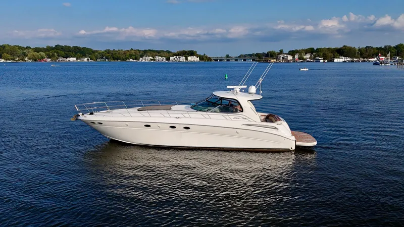 Slide: The Image of 2001 Sea Ray 510 Sundancer yacht on calm blue water, scenic background. - 13