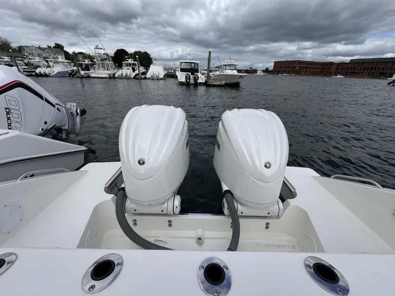 Slide: The Image of 2023 Pursuit S 328 Sport boat with twin engines docked in a marina. - 11