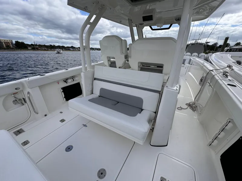 Slide: The Image of 2023 Pursuit S 328 Sport boat interior with seating, on a calm waterway. - 19