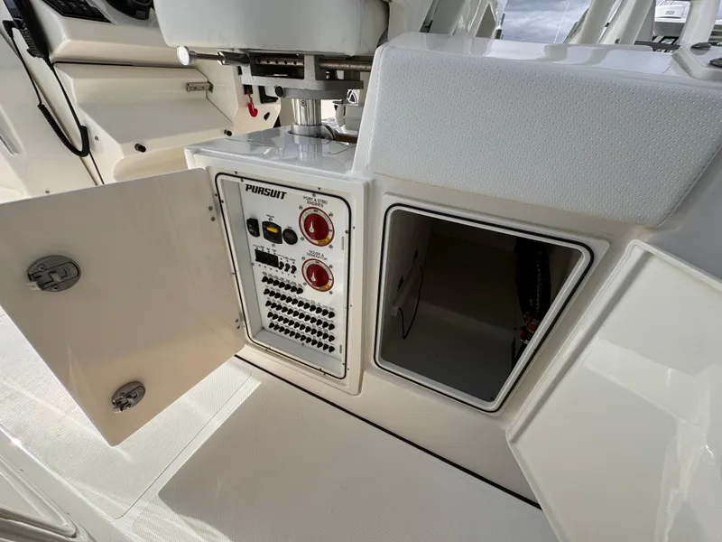 Slide: The Image of 2023 Pursuit S 328 Sport boat control panel with open storage compartment. - 25