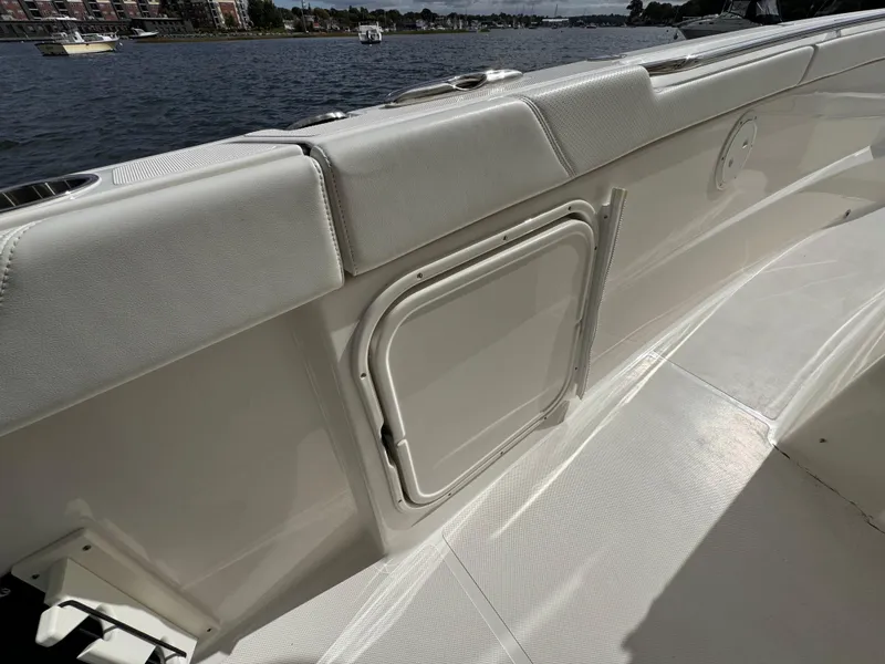 Slide: The Image of 2023 Pursuit S 328 Sport boat interior with white seating and storage compartment. - 26