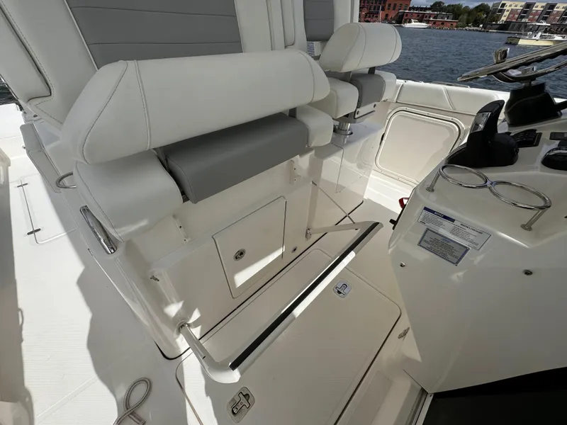 Slide: The Image of 2023 Pursuit S 328 Sport boat interior with white seating and helm controls. - 29
