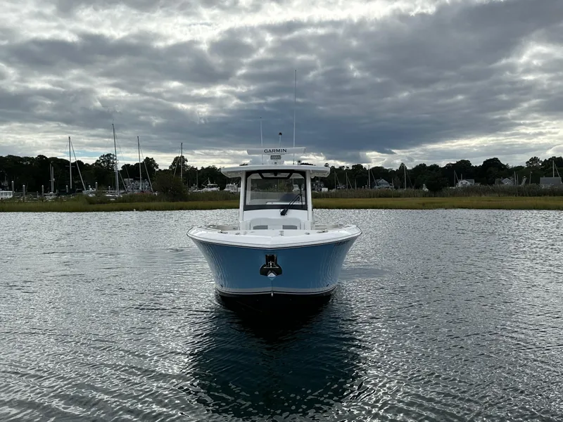 Slide: The Image of 2023 Pursuit S 328 Sport boat on calm water under cloudy sky. - 3
