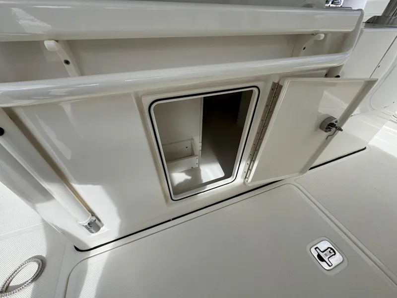 Slide: The Image of 2023 Pursuit S 328 Sport boat storage compartment with open door. - 30