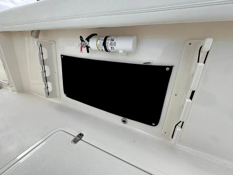 Slide: The Image of 2023 Pursuit S 328 Sport boat interior with fire extinguisher and storage compartment. - 33