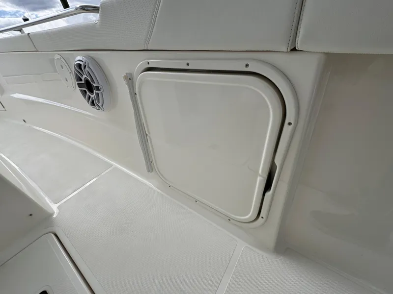 Slide: The Image of 2023 Pursuit S 328 Sport boat interior with storage compartment and speaker. - 34