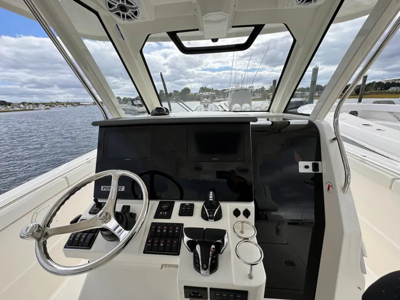 Slide: The Image of 2023 Pursuit S 328 Sport boat cockpit with steering wheel and control panel. - 36