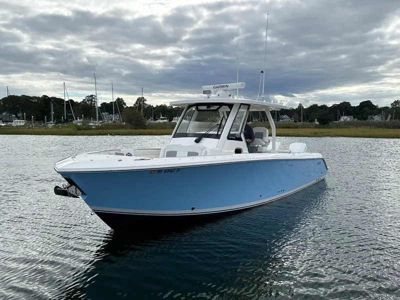 Slide: The Image of 2023 Pursuit S 328 Sport boat on calm water under cloudy sky. - 4