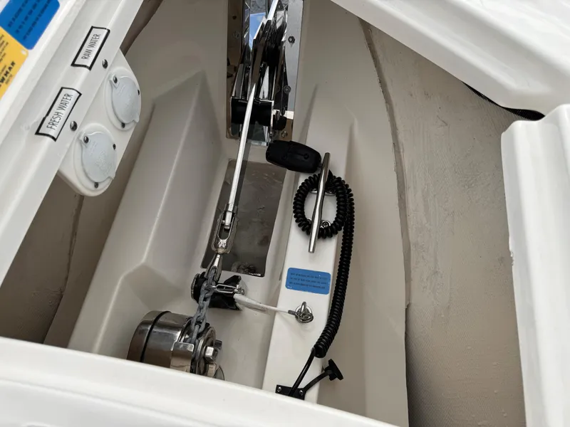 Slide: The Image of 2023 Pursuit S 328 Sport boat anchor compartment with winch and rope. - 44