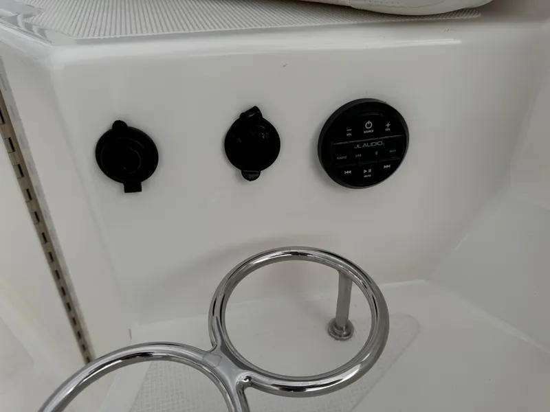 Slide: The Image of 2023 Pursuit S 328 Sport boat dashboard with controls and cup holder. - 46