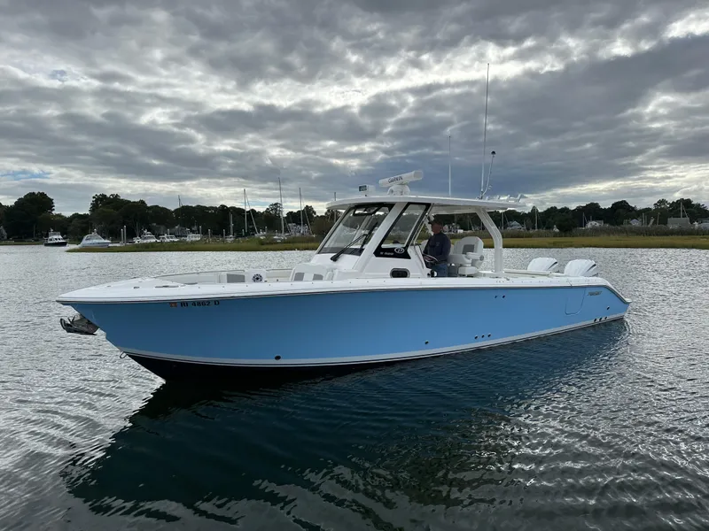 Slide: The Image of 2023 Pursuit S 328 Sport boat on calm water under cloudy sky. - 5