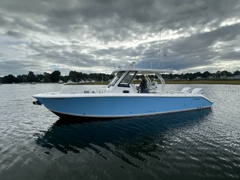 Slide: The Image of 2023 Pursuit S 328 Sport boat on calm water under cloudy sky. - 6
