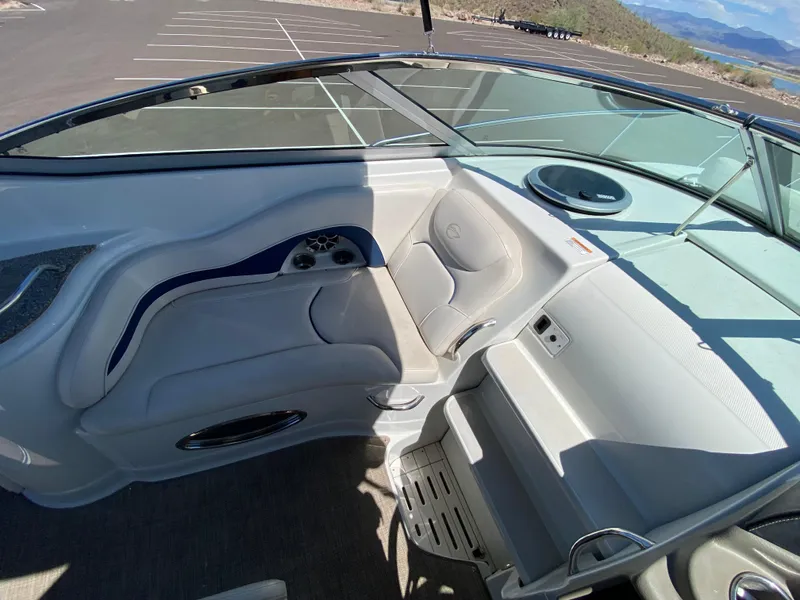 Slide: The Image of 2022 Crownline 264 CR boat interior with seating and dashboard, parked in a lot. - 15