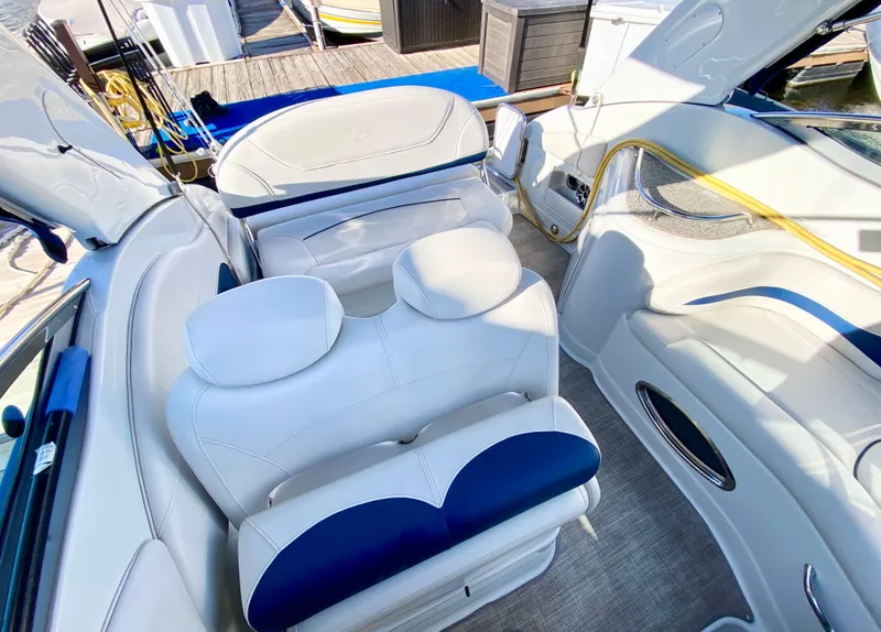 Slide: The Image of 2022 Crownline 264 CR boat interior with white and blue seating, docked at marina. - 31