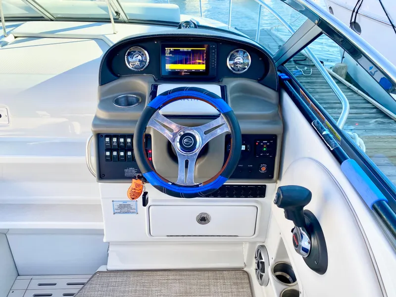Slide: The Image of 2022 Crownline 264 CR boat dashboard with steering wheel and control panel. - 33