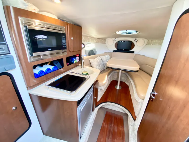 Slide: The Image of 2022 Crownline 264 CR cabin interior with kitchenette and seating area. - 35