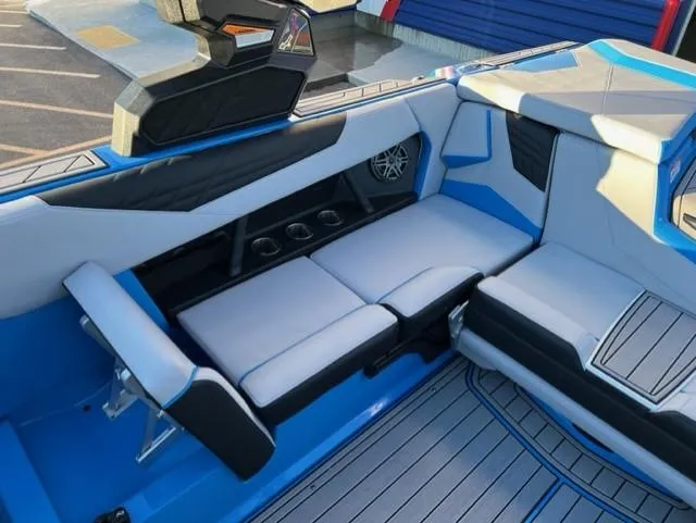 Slide: The Image of 2023 Nautique S23 boat interior with blue and gray seating and cup holders. - 14