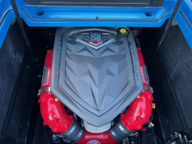 Slide: The Image of 2023 Nautique S23 engine with PCM cover, featuring red components and blue surroundings. - 16