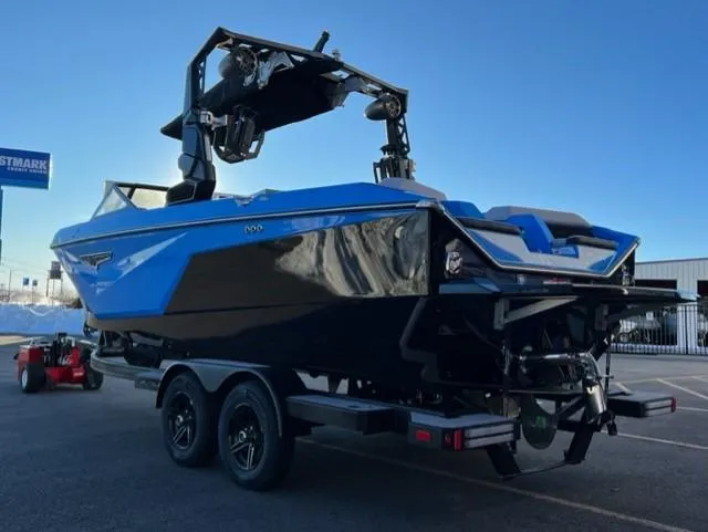 Slide: The Image of 2023 Nautique S23 boat in blue and black on a trailer, parked outdoors. - 4