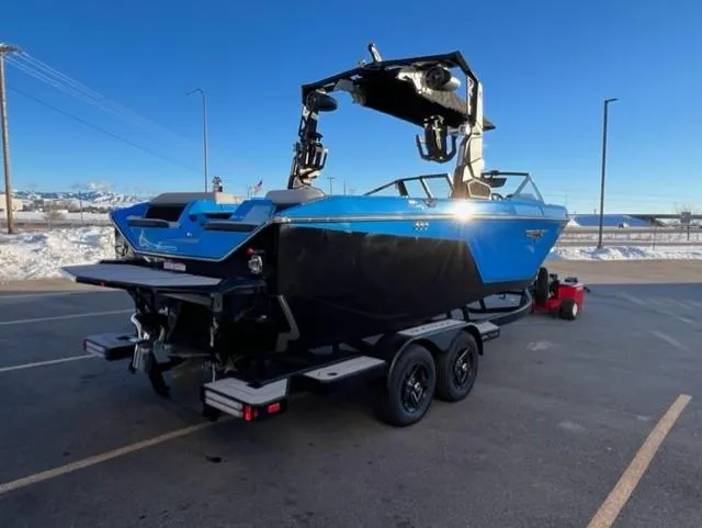 Slide: The Image of 2023 Nautique S23 boat on trailer in sunny parking lot. - 6