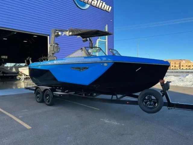 Slide: The Image of 2023 Nautique S23 boat in blue and black, parked outside a dealership. - 8