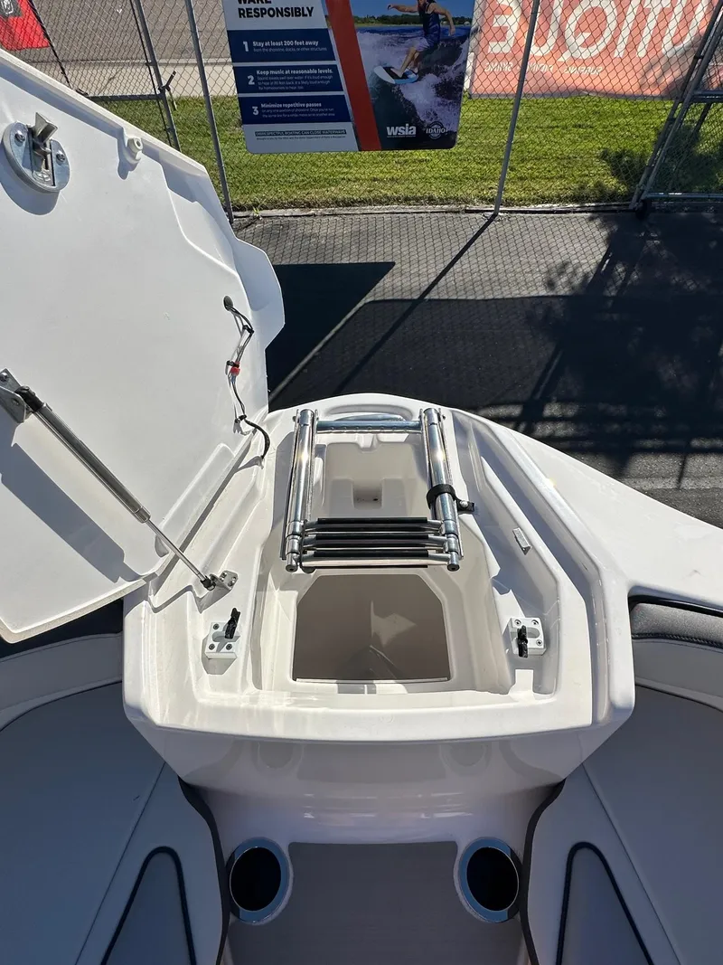 Slide: The Image of 2023 Yamaha AR250 jet boat with open storage compartment and ladder. - 14