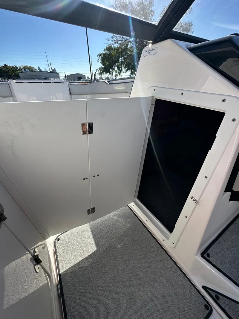 Slide: The Image of 2023 Yamaha AR250 boat interior with open storage compartment and carpeted flooring. - 19