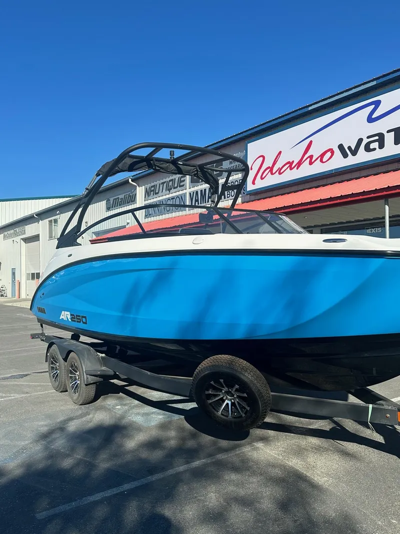 Slide: The Image of 2023 Yamaha AR250 jet boat in blue, parked outside dealership. - 3