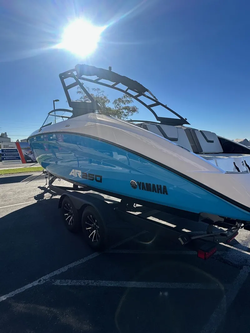 Slide: The Image of 2023 Yamaha AR250 jet boat on trailer under bright sun. - 7