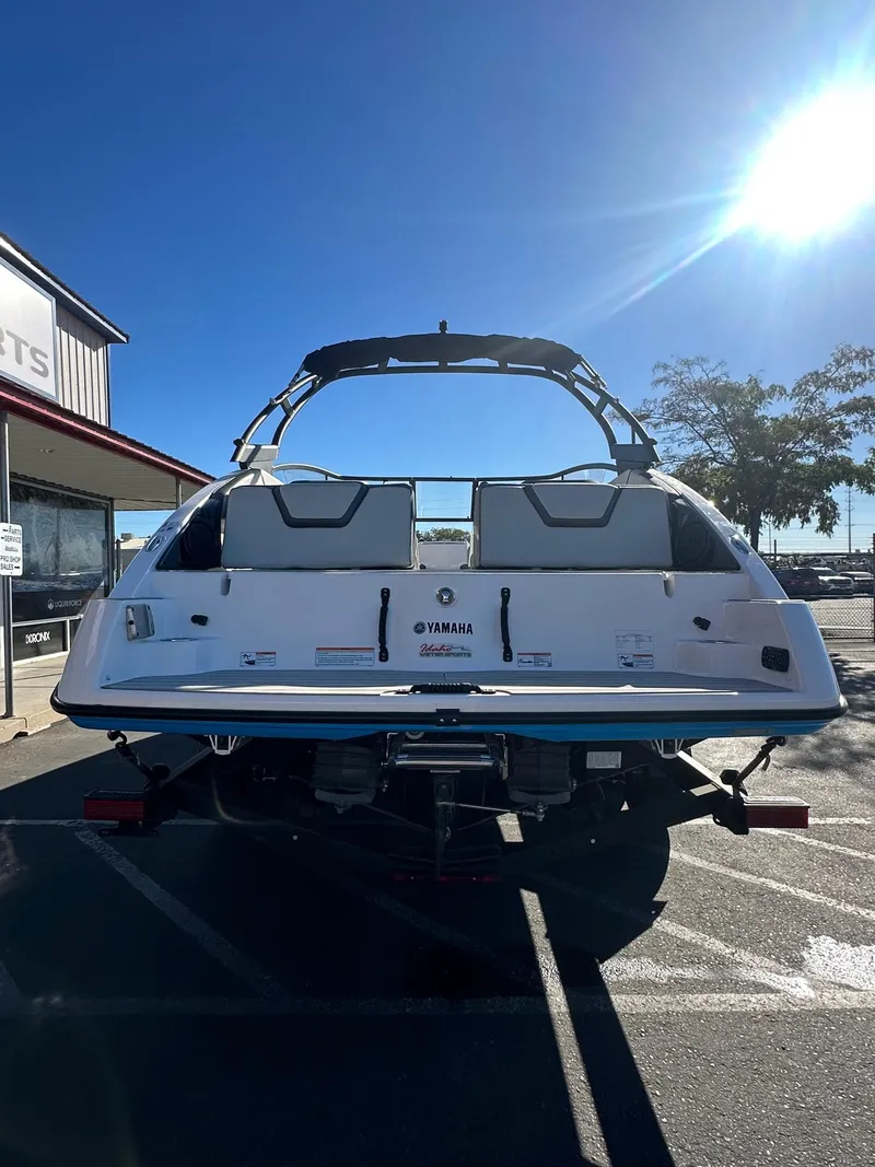 Slide: The Image of 2023 Yamaha AR250 jet boat rear view in parking lot under clear blue sky. - 8