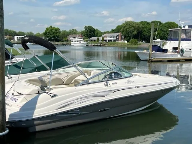 Slide: The Image of 2006 Sea Ray 200 Sundeck boat docked in a serene marina setting. - 12