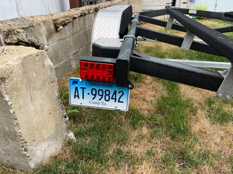 Slide: The Image of Trailer with Connecticut license plate AT-99842, parked on grass near a concrete wall. - 8