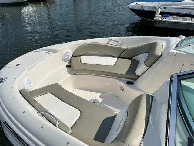 Slide: The Image of 2006 Sea Ray 200 Sundeck boat with spacious seating, docked on calm water. - 9
