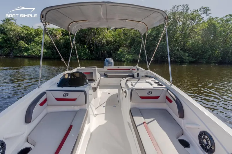 Slide: The Image of 2023 Hurricane SunDeck Sport 205 OB boat on a calm river, featuring spacious seating and canopy. - 4