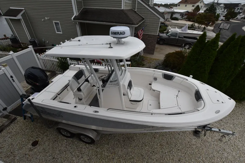 Slide: The Image of 2023 Robalo R230 Center Console boat on trailer in residential driveway. - 11