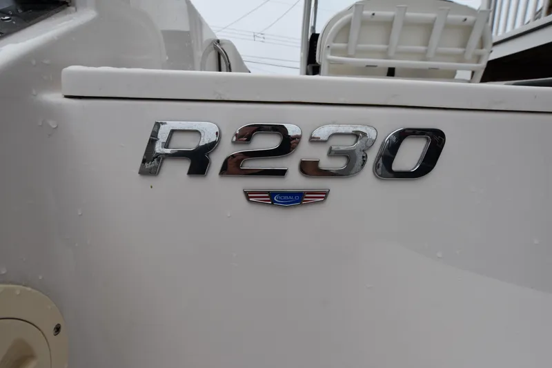 Slide: The Image of 2023 Robalo R230 Center Console boat emblem on white surface. - 14