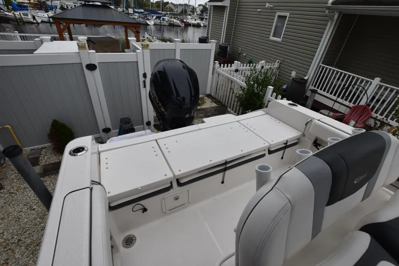 Slide: The Image of 2023 Robalo R230 Center Console boat with seating and storage, docked near a marina. - 15