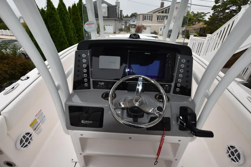 Slide: The Image of 2023 Robalo R230 Center Console boat dashboard with steering wheel and navigation controls. - 22
