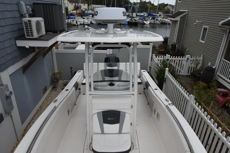 Slide: The Image of 2023 Robalo R230 Center Console boat docked near houses and marina. - 26