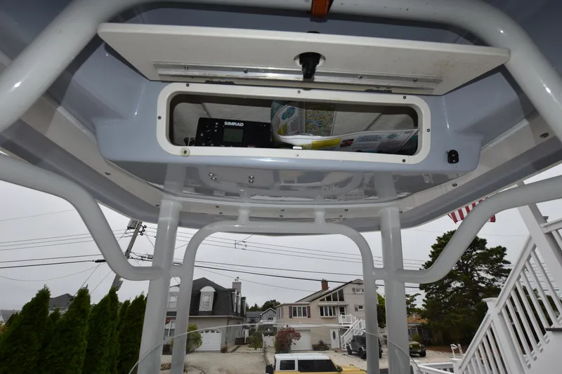 Slide: The Image of 2023 Robalo R230 Center Console T-top storage compartment with electronics and accessories. - 29