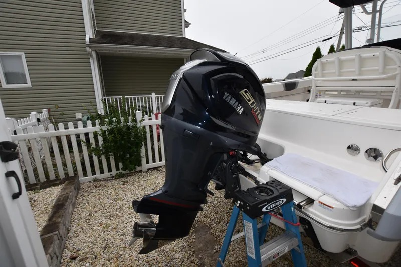 Slide: The Image of 2023 Robalo R230 Center Console with Yamaha outboard motor in a residential setting. - 6