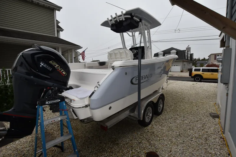 Slide: The Image of 2023 Robalo R230 Center Console boat on trailer, parked in driveway. - 7